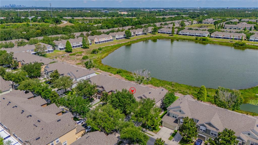An aerial view shows a residential neighborhood with townhomes surrounding a large retention pond — 4939 POND RIDGE DRIVE, RIVERVIEW, FL