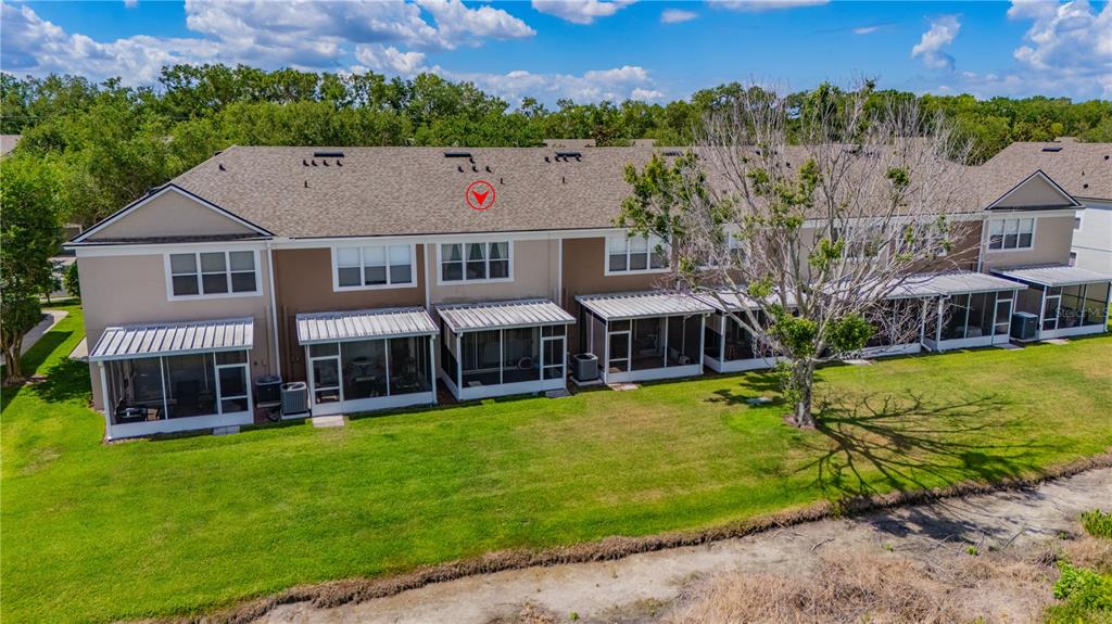 An aerial view of the rear exterior of a multi-unit townhouse complex with screened patios — 4939 POND RIDGE DRIVE, RIVERVIEW, FL