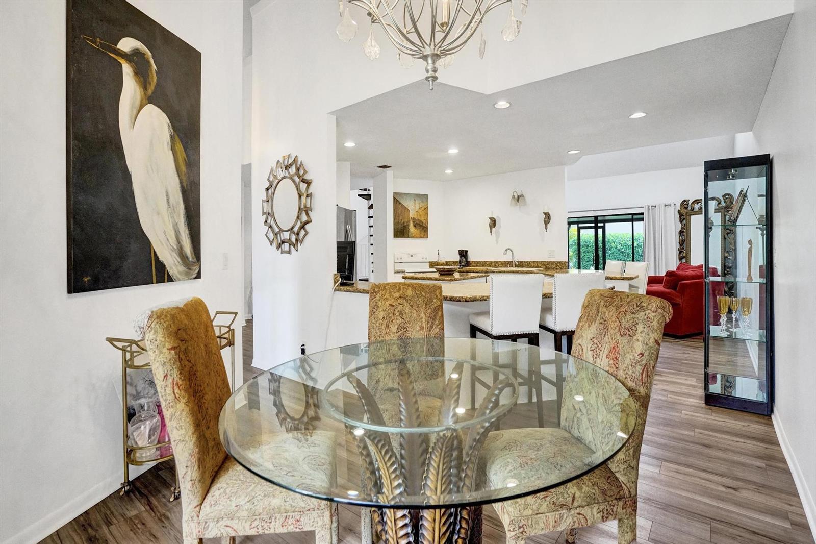 A dining area with a glass table and patterned chairs opens into a kitchen — 23417 Water Circle, Boca Raton FL 33486, BOCA RATON, FL