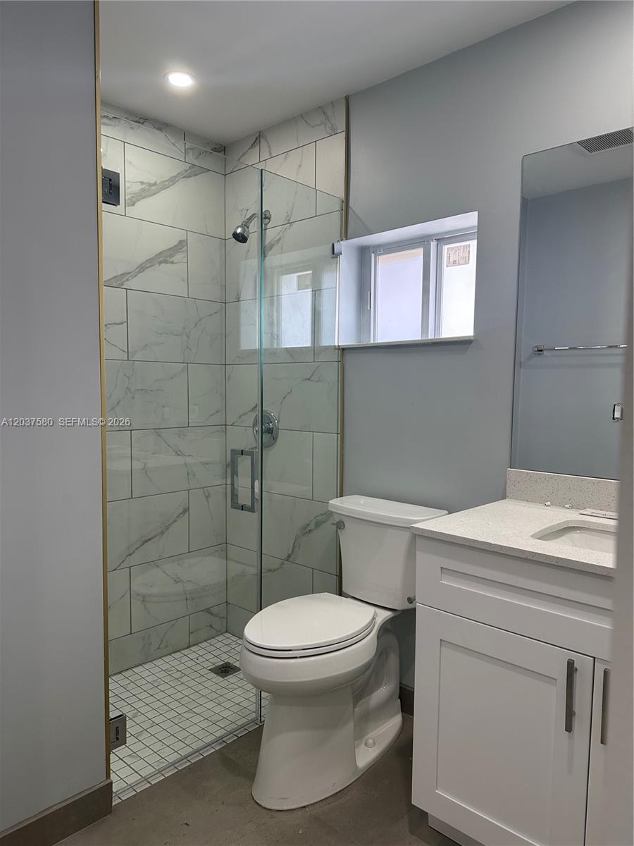 A bathroom features a glass-enclosed shower with marble-look tile, a white vanity, and a toilet — 1628 NW 15th St # A, Miami FL 33125, MIAMI, FL