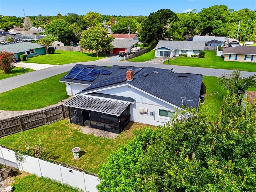 An aerial view of a single-story house with a screened patio and rooftop solar panels — 408 LANIER LANE, WINTER HAVEN, FL