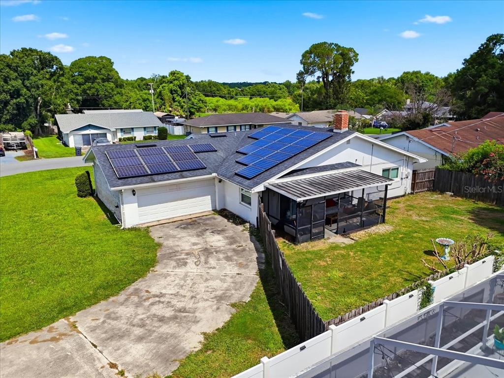 An aerial view of a single-story house with solar panels on the roof and a driveway — 408 LANIER LANE, WINTER HAVEN, FL