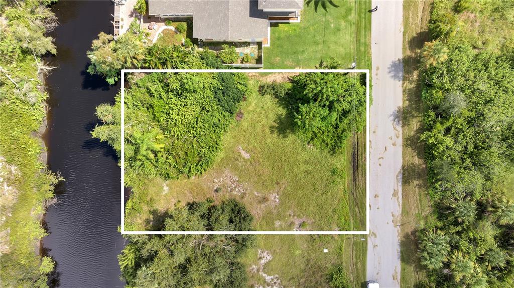 An aerial view shows a rectangular vacant lot bordered by a canal and a road — 27438 SAN MARCO DRIVE, PUNTA GORDA, FL