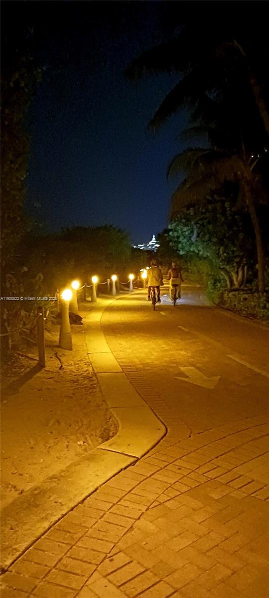 A paved path illuminated by bollard lights at night with two people riding bicycles — 2401 Collins Ave # 1708, Miami Beach FL 33140, MIAMI BEACH, FL