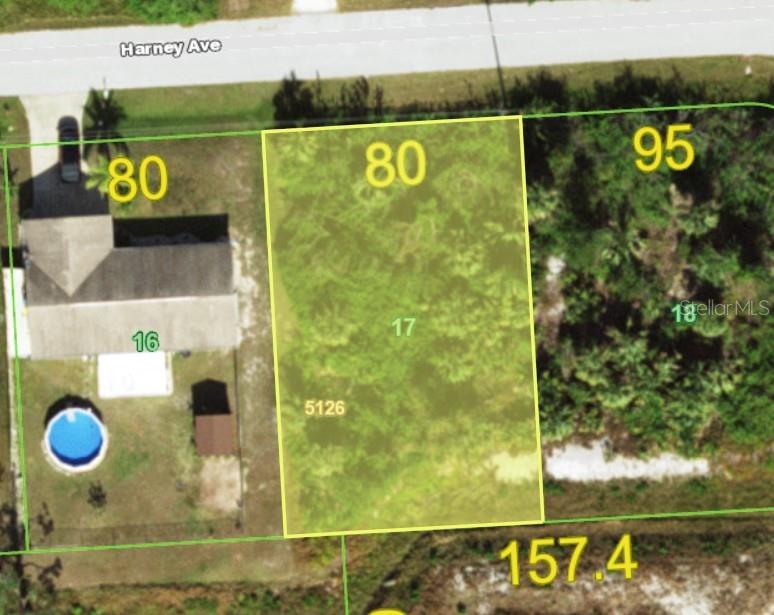 This is an aerial map showing a rectangular vacant lot highlighted in yellow between two properties — 13323 HARNEY AVENUE, PORT CHARLOTTE, FL