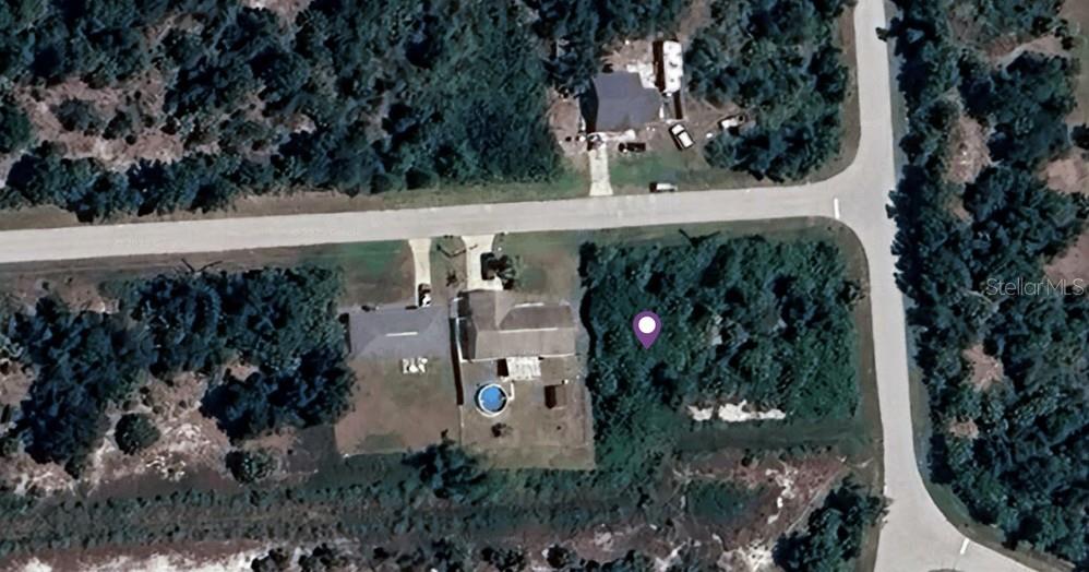 This aerial map view shows a residential property with a house, pool, and wooded lot — 13323 HARNEY AVENUE, PORT CHARLOTTE, FL