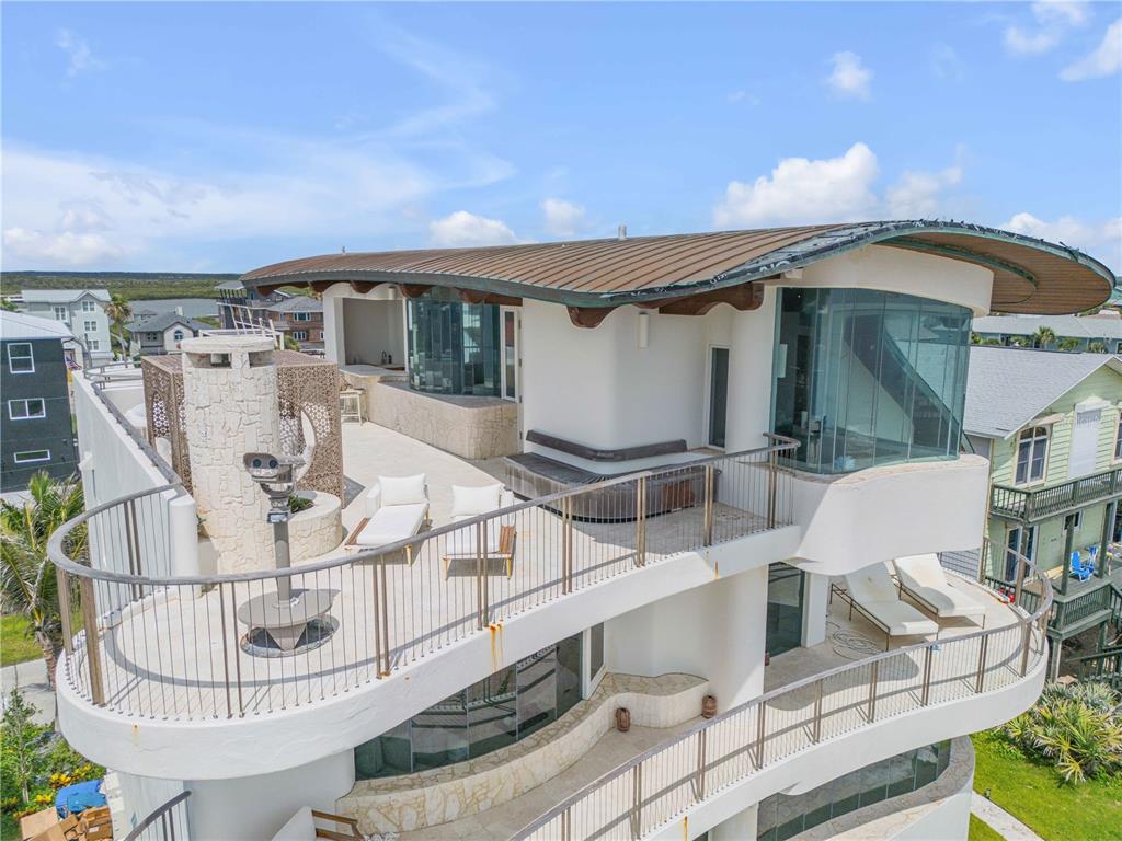 An aerial view of a modern house exterior featuring a large rooftop terrace with railings — 6965 S ATLANTIC AVENUE, NEW SMYRNA BEACH, FL