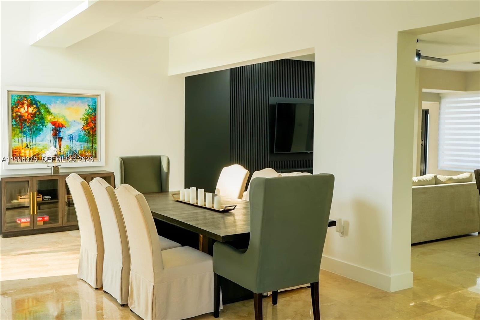 A dining room features a dark wood table, upholstered chairs, and a black slatted accent wall — 290 NW 125th Ave, Miami FL 33182, MIAMI, FL