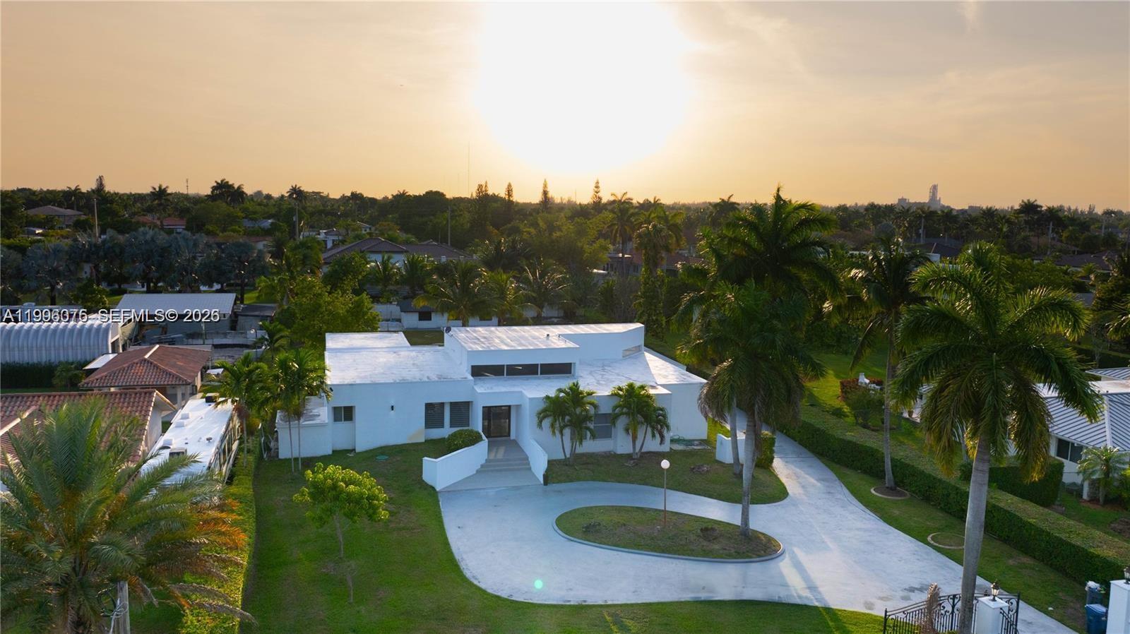 An aerial view shows a white modern house with a circular driveway and palm trees — 290 NW 125th Ave, Miami FL 33182, MIAMI, FL