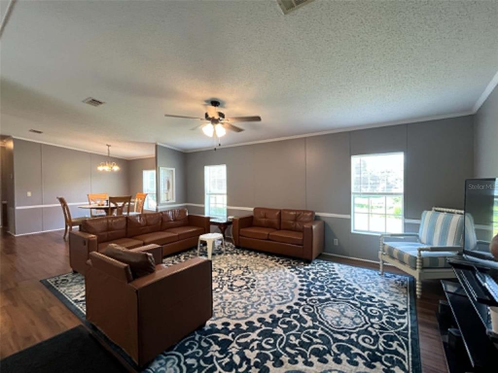 A living room features brown leather furniture, a patterned area rug, and a dining area — 123 AMOS ROAD, CRESCENT CITY, FL