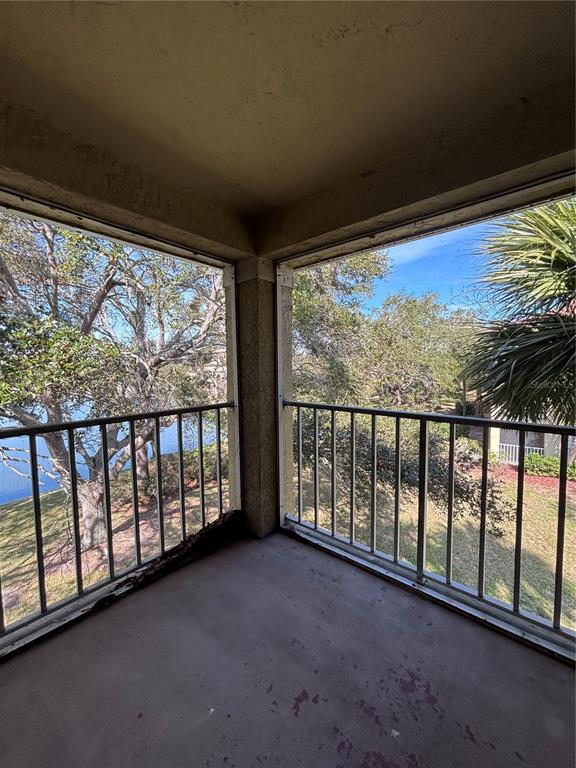 A covered balcony with metal railings overlooks a lake and trees — 2690 CORAL LANDINGS BOULEVARD UNIT 538, PALM HARBOR, FL