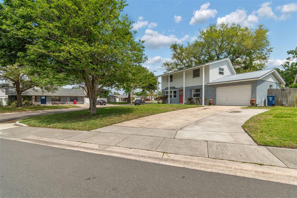 A two-story house with a white garage and a concrete driveway under a blue sky — 8043 124TH STREET, SEMINOLE, FL