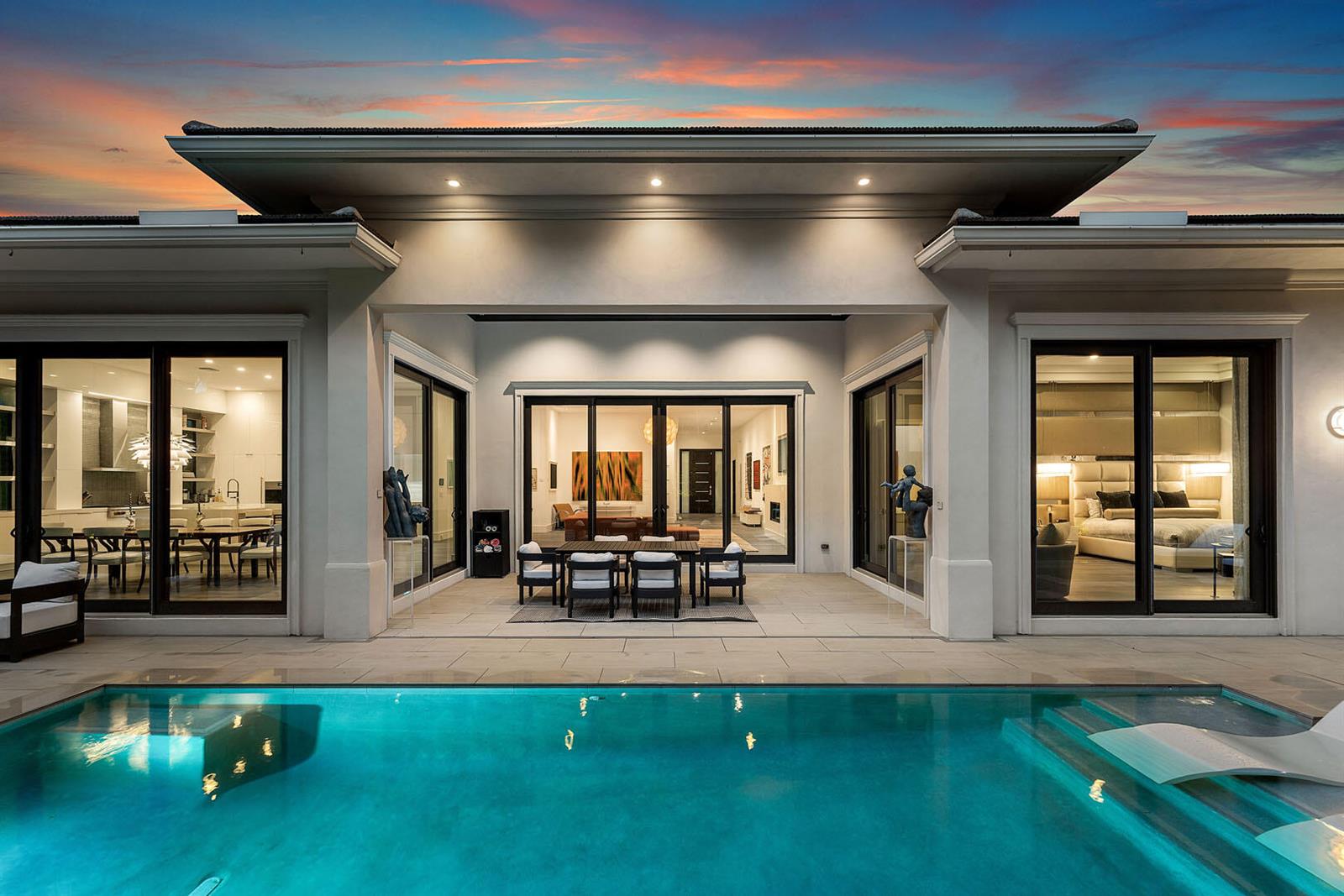A modern house exterior with a swimming pool, outdoor dining area, and large glass doors — 2351 Cherry Palm Road, Boca Raton FL 33432, BOCA RATON, FL