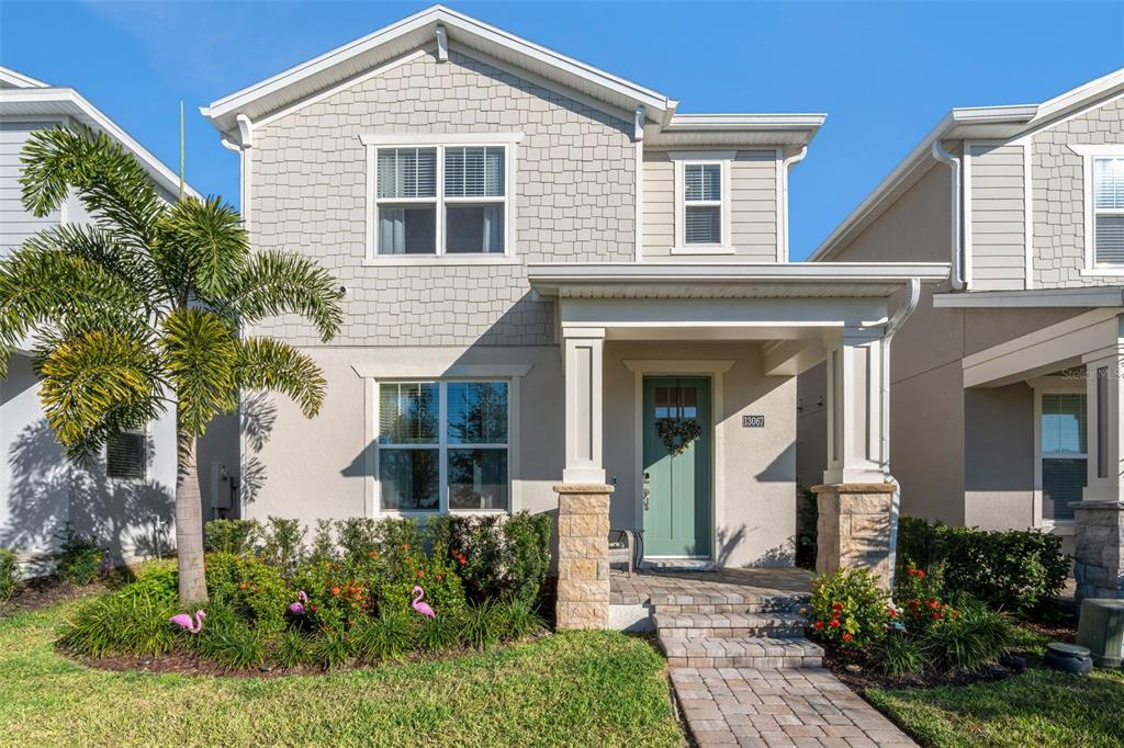 A two-story suburban house with a teal front door, stone-based columns, and a palm tree — 13067 TOLLCROSS WAY, WINTER GARDEN, FL