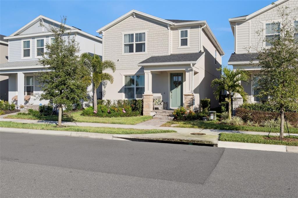 A two-story suburban house with light siding, a covered front porch, and a paved walkway — 13067 TOLLCROSS WAY, WINTER GARDEN, FL
