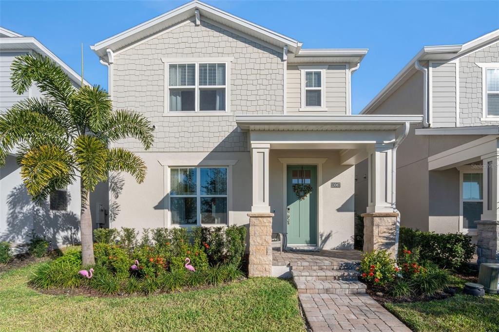 A two-story house with a light-colored facade, shingled upper siding, and a covered front porch — 13067 TOLLCROSS WAY, WINTER GARDEN, FL