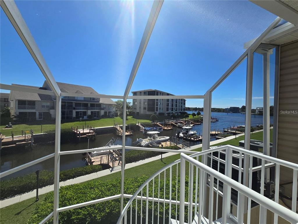A screened-in balcony overlooks a canal with boat docks and multi-story residential buildings — 8222 BRENT STREET, PORT RICHEY, FL