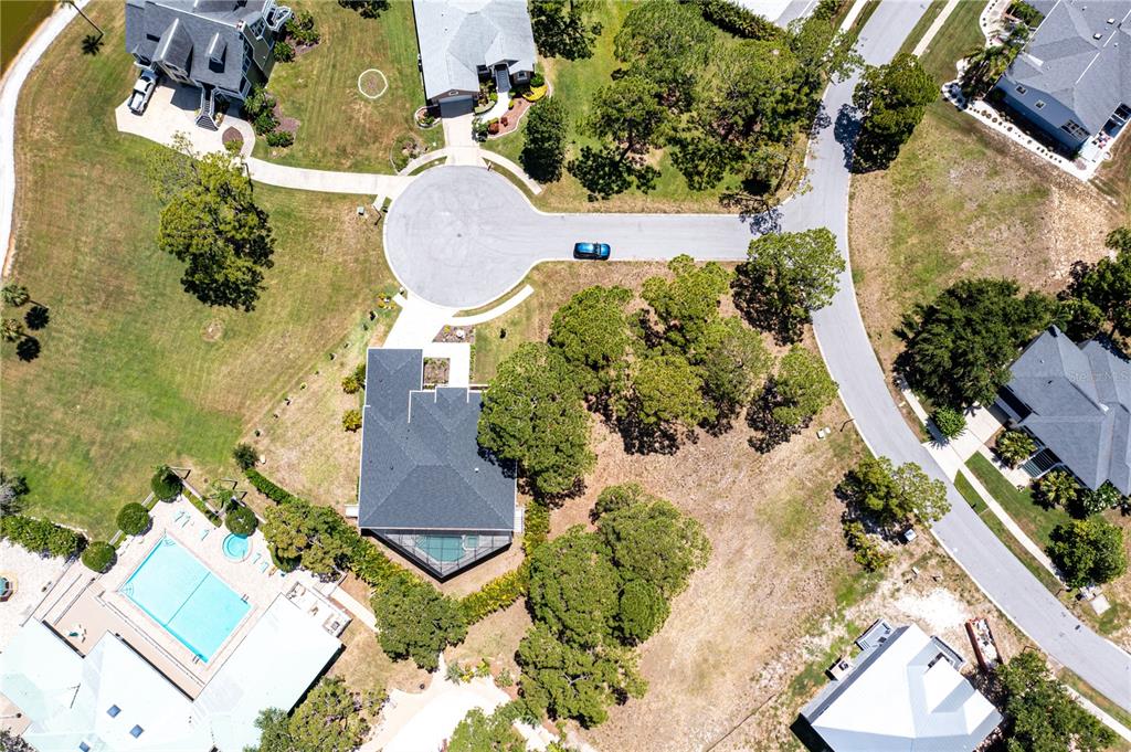 An aerial view shows a residential house with a pool and trees in a cul-de-sac — OTTER CT, TARPON SPRINGS, FL