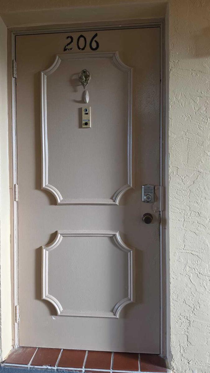 A beige apartment door labeled 206 features a door knocker, peephole, and electronic keypad lock — 100 Ashbury Road # 206, Hollywood FL 33024, HOLLYWOOD, FL