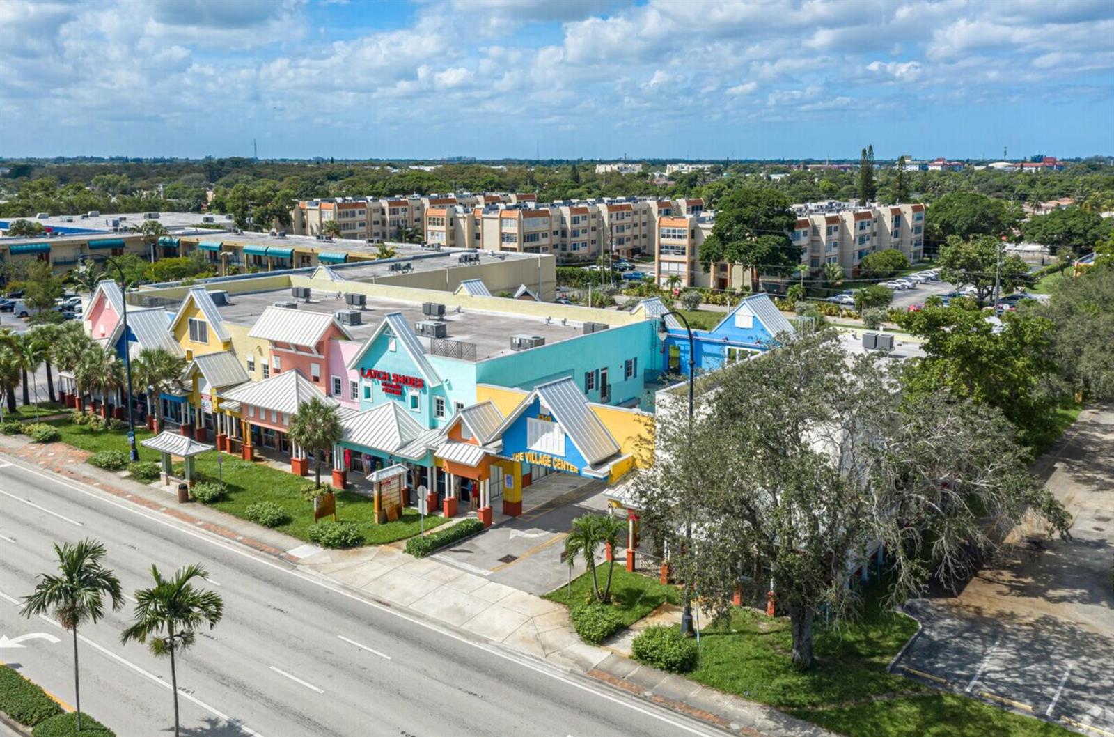 An aerial view shows a colorful multi-tenant commercial building with a parking lot and road — 2349 N State Road 7, Lauderhill FL 33313, LAUDERHILL, FL