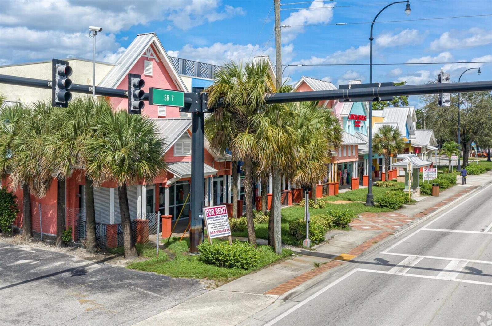 An exterior view of a colorful commercial strip mall with palm trees and a rental sign — 2349 N State Road 7, Lauderhill FL 33313, LAUDERHILL, FL