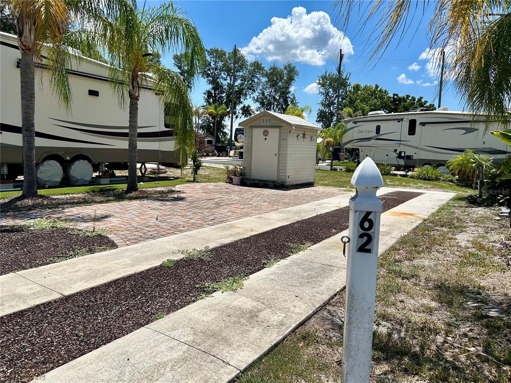 A paved lot with a small shed sits between two parked recreational vehicles — 2928 BIRDIE DRIVE, BOWLING GREEN, FL