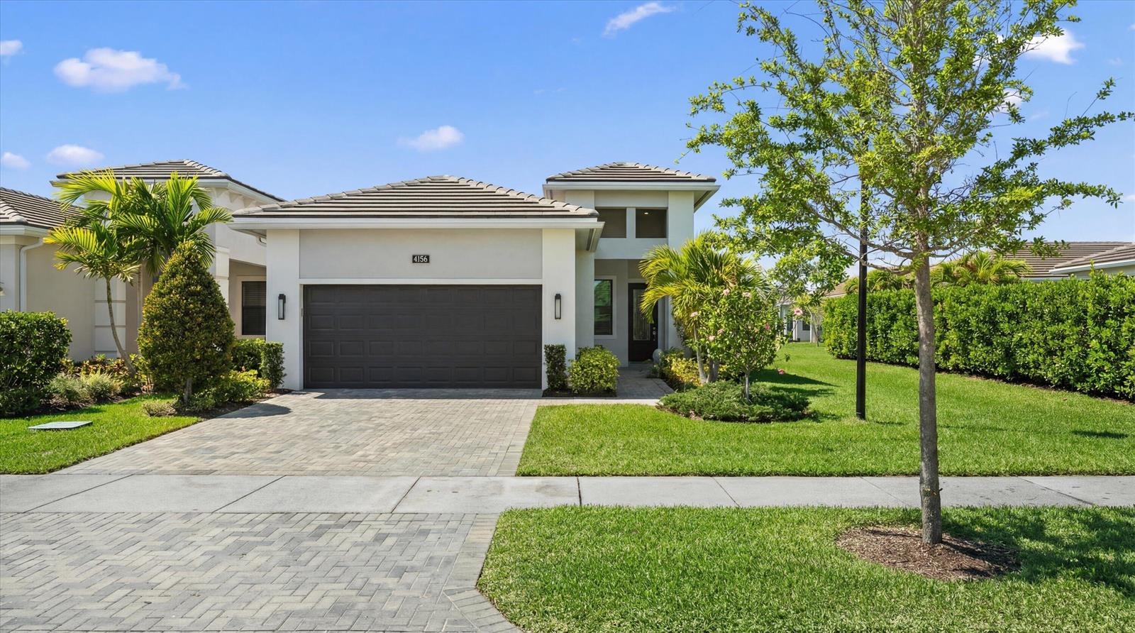 A single-story house with a paved driveway, a two-car garage, and a landscaped front yard — 4786 Saint Armands Way, Westlake FL 33470, WESTLAKE, FL