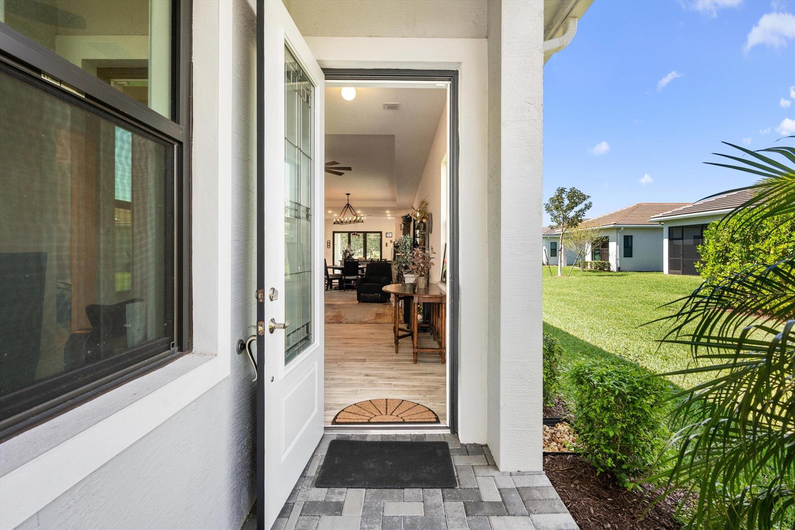 An open front door reveals a view into a home's interior with tiled flooring — 4786 Saint Armands Way, Westlake FL 33470, WESTLAKE, FL