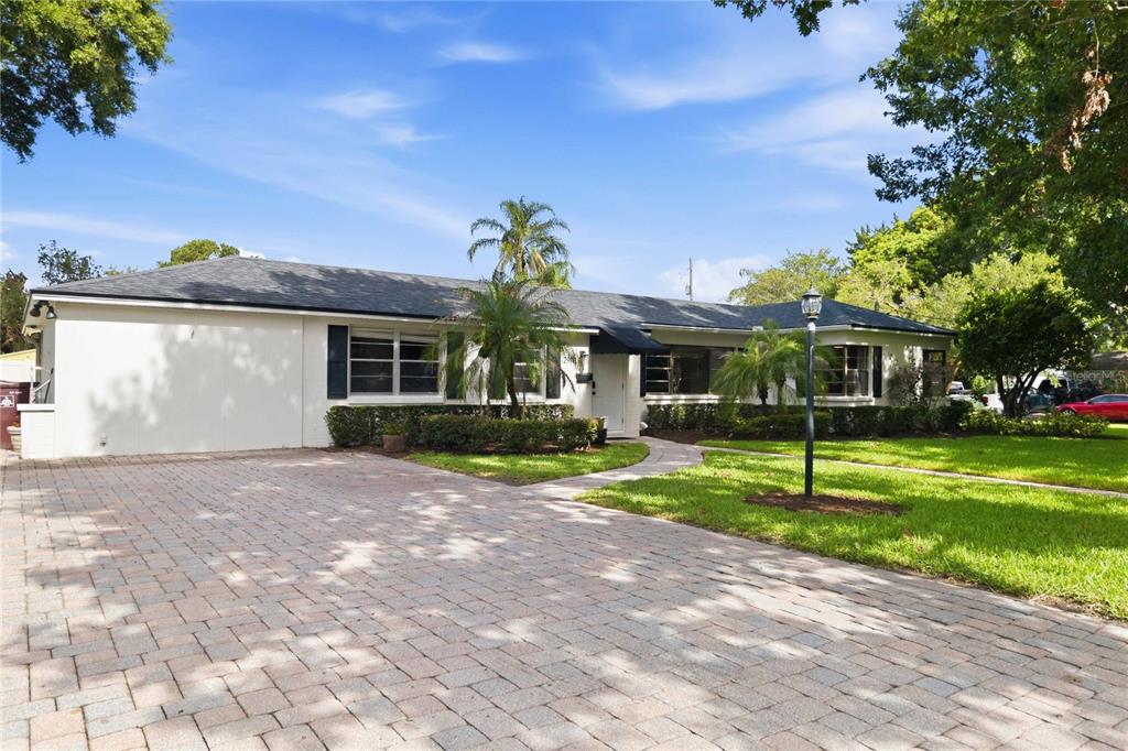 A single-story white house with a brick paver driveway and a dark shingled roof — 2918 CARL TERRACE, ORLANDO, FL