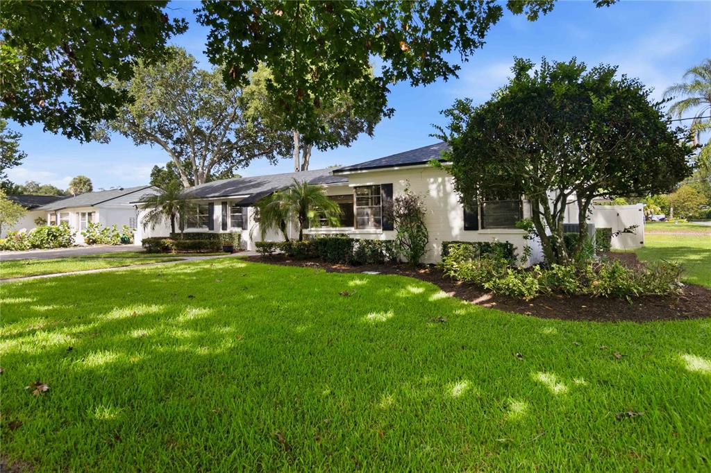 A single-story white house with a dark roof sits behind a large, green front lawn — 2918 CARL TERRACE, ORLANDO, FL