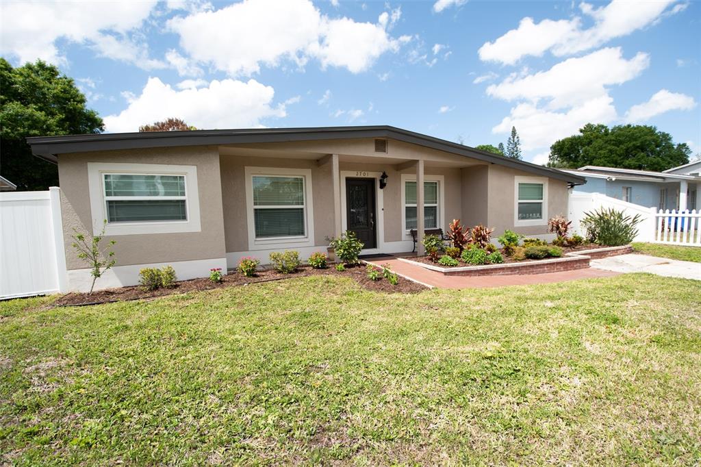 A single-story house with a tan exterior, a covered entryway, and a front lawn — 2701 CALLE STREET, TAMPA, FL