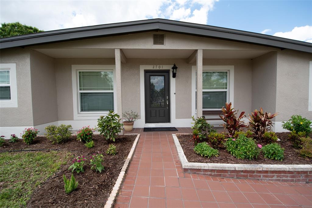 The front exterior of a single-story house features a tiled walkway leading to the entrance — 2701 CALLE STREET, TAMPA, FL