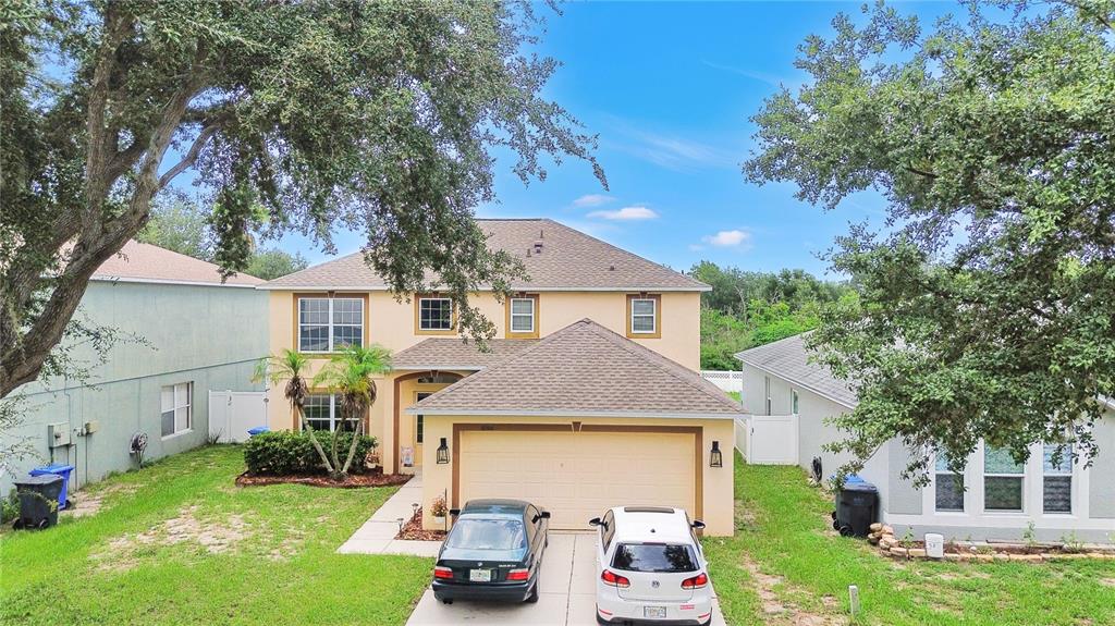 An aerial view of a two-story suburban house with a two-car garage and two vehicles — 10304 RIVER BREAM DRIVE, RIVERVIEW, FL