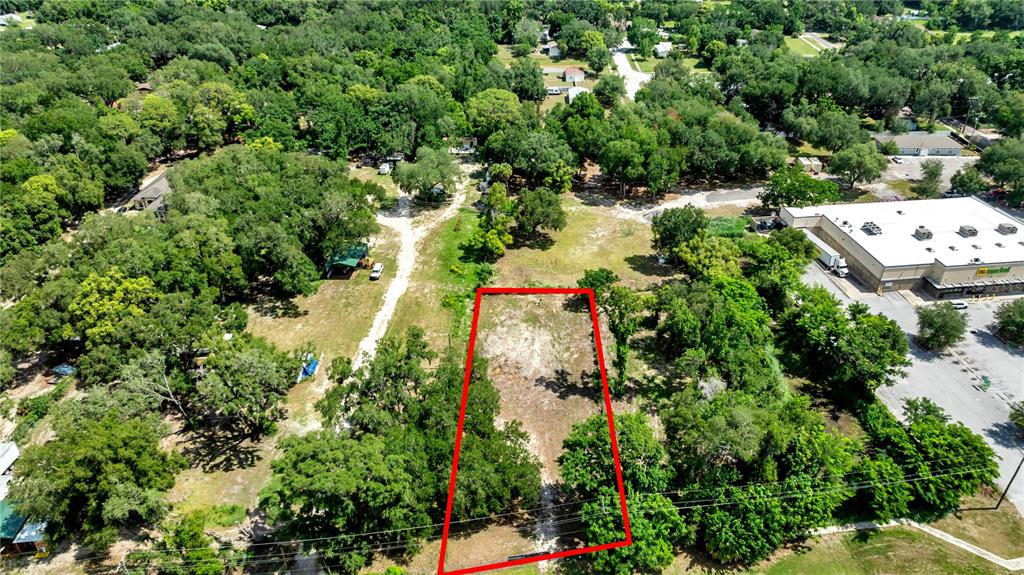 An aerial view shows a rectangular plot of land outlined in red near a commercial building — 9924 ROCKHILL ROAD, THONOTOSASSA, FL