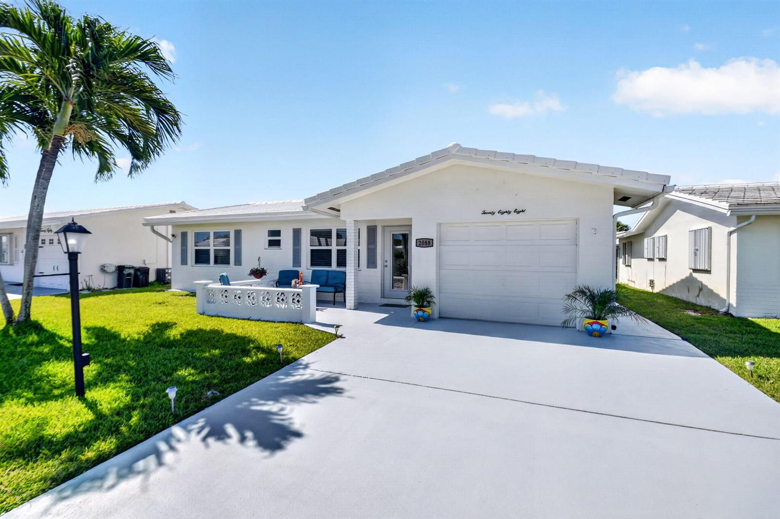 A white single-story house with a garage, a small patio, and a palm tree — 2088 SW 13th Terrace, Boynton Beach FL 33426, BOYNTON BEACH, FL