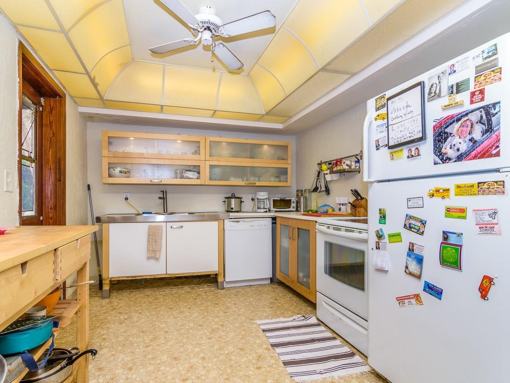 A kitchen with light wood cabinets, white appliances, a ceiling fan, and a patterned floor — 3136 W EUCLID AVENUE, TAMPA, FL