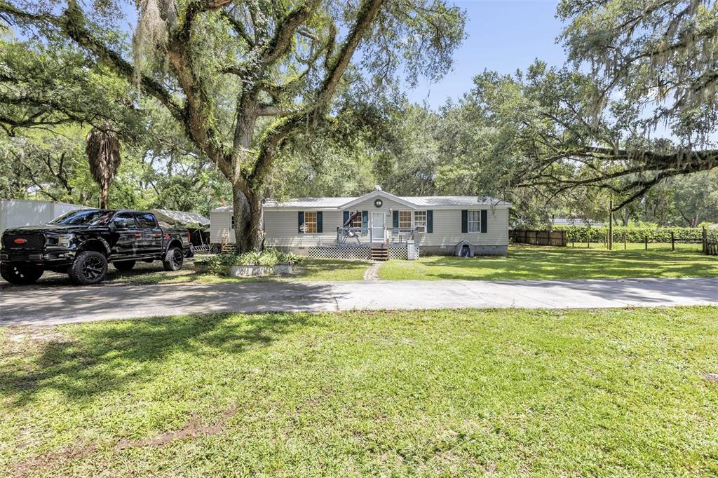 A single-story manufactured home sits on a grassy lot with a large pickup truck parked nearby — 1705 SE 179 PLACE, SUMMERFIELD, FL