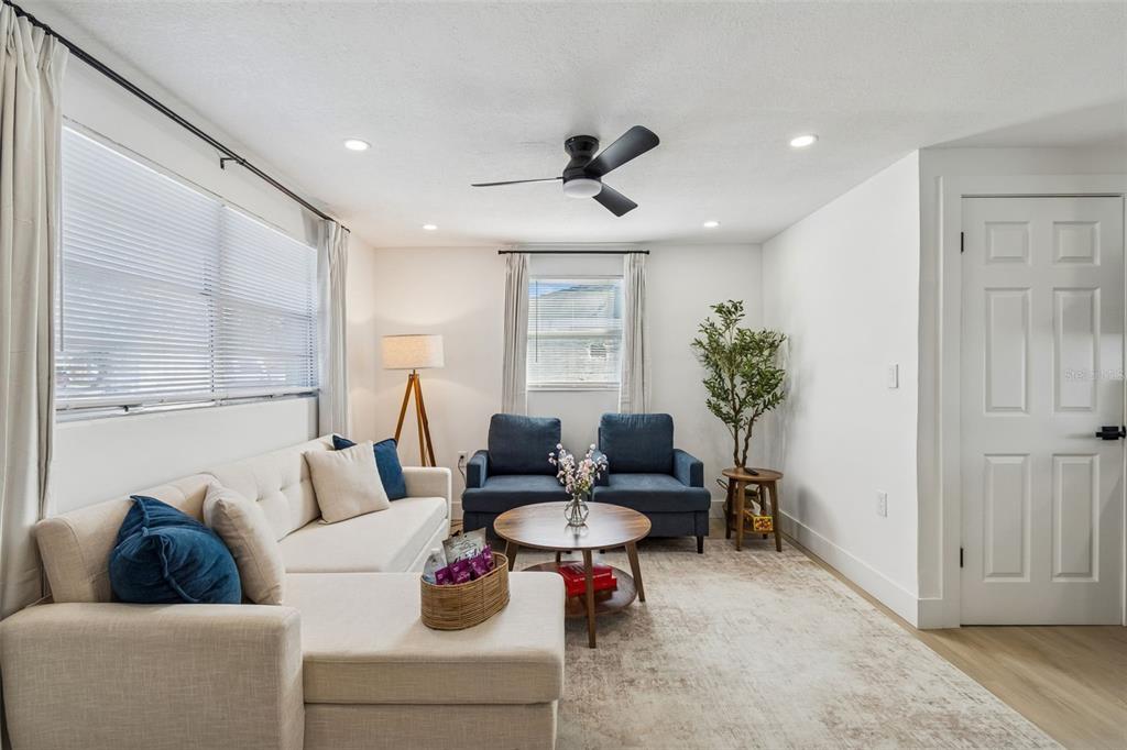 A living room features a beige sectional sofa, two blue armchairs, and a coffee table — 13264 120TH LANE, LARGO, FL