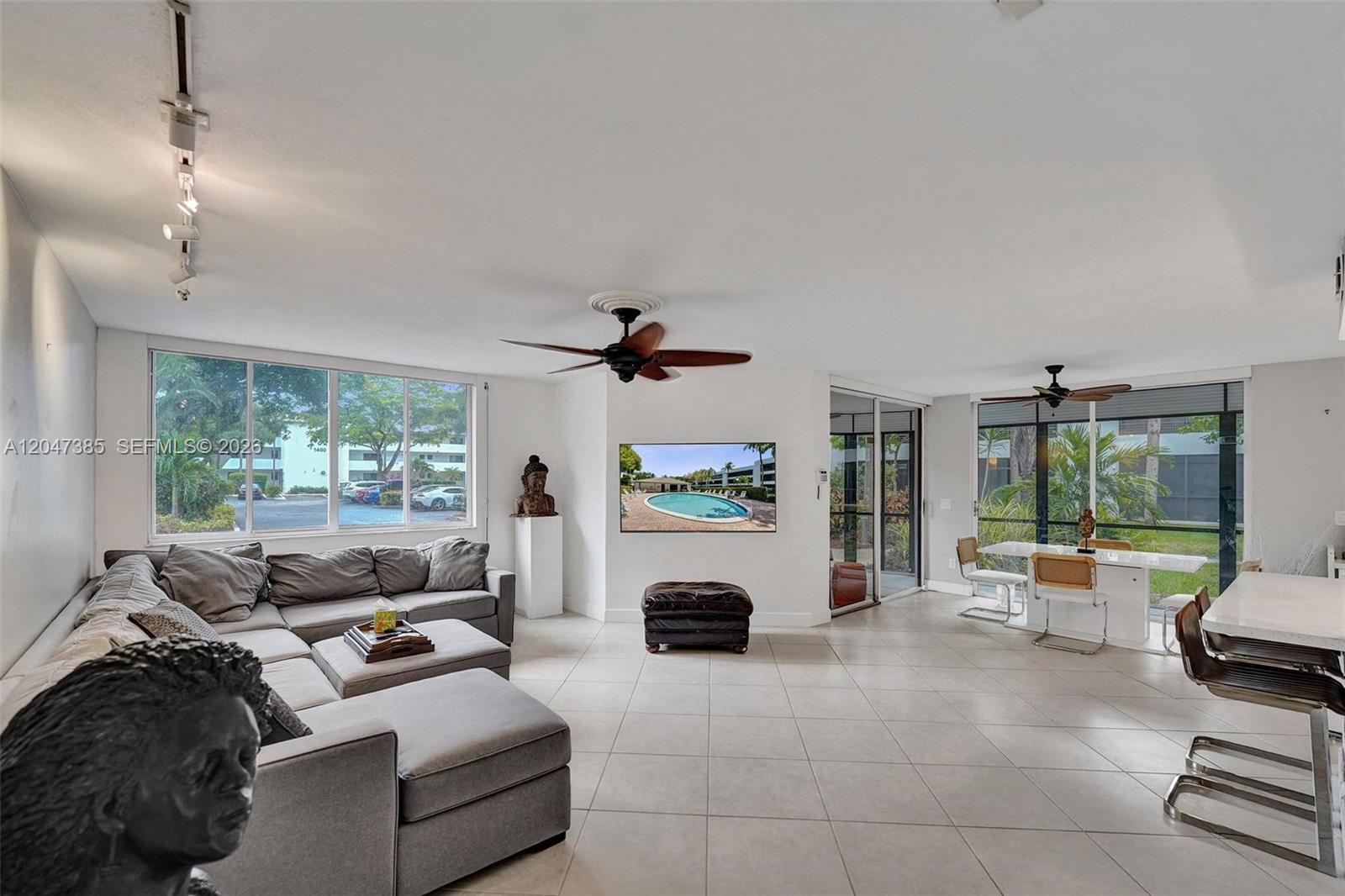 A living and dining area features tile floors, a sectional sofa, and large windows — 1430 Sheridan St # 1G, Hollywood FL 33020, HOLLYWOOD, FL