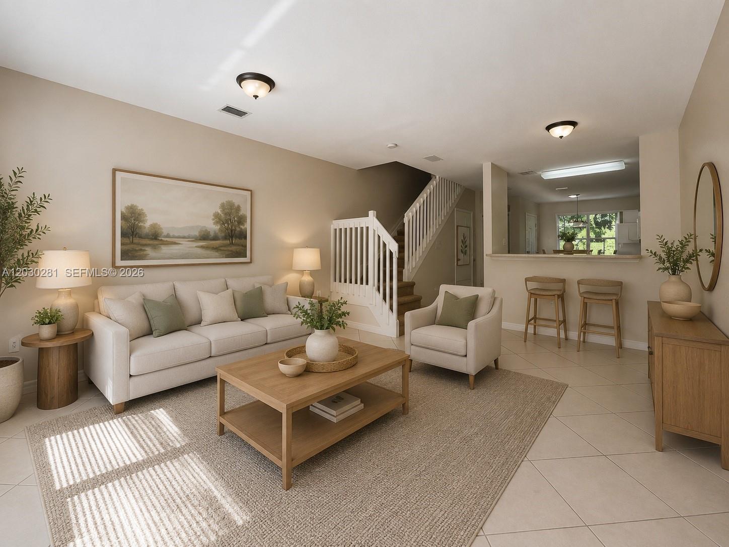 This living room features a beige sofa, wooden coffee table, and stairs leading upward — 1932 Alamanda Way # 1932, Riviera Beach FL 33404, RIVIERA BEACH, FL