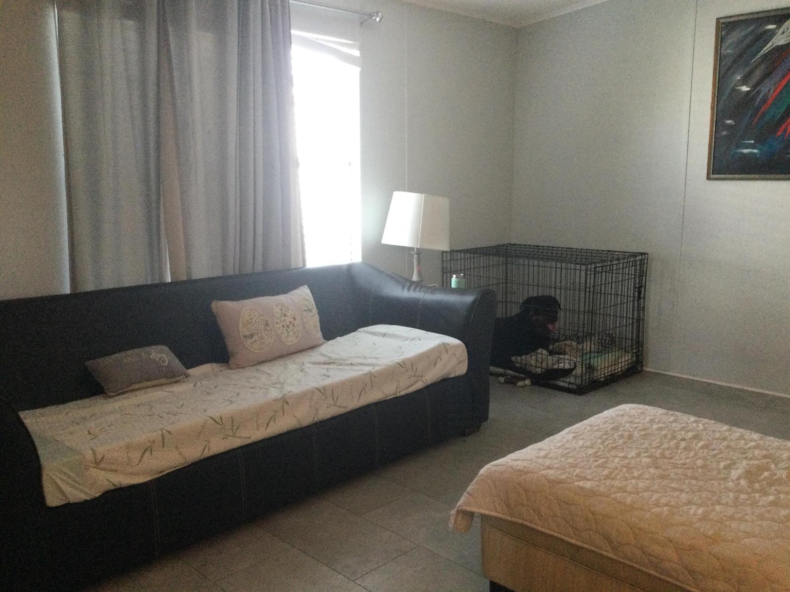 A living room features a dark sofa, a dog crate, and a lamp near a window — 4748 SE Balsawood Terrace, Stuart FL 34997, STUART, FL