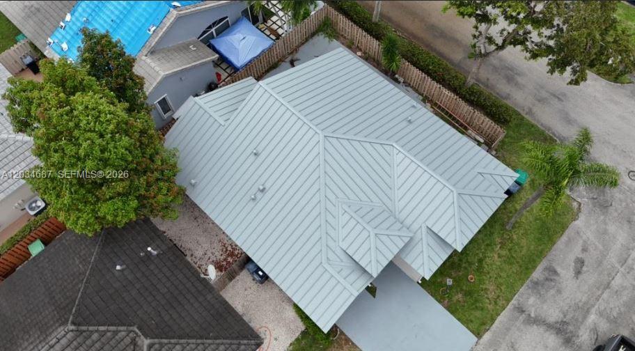 An aerial view shows a house with a light gray metal roof and a driveway — 12338 SW 144th Ter, Miami FL 33186, MIAMI, FL