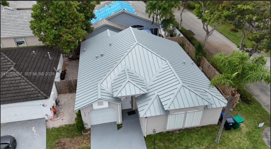 An aerial view shows a single-story house with a light gray metal roof — 12338 SW 144th Ter, Miami FL 33186, MIAMI, FL