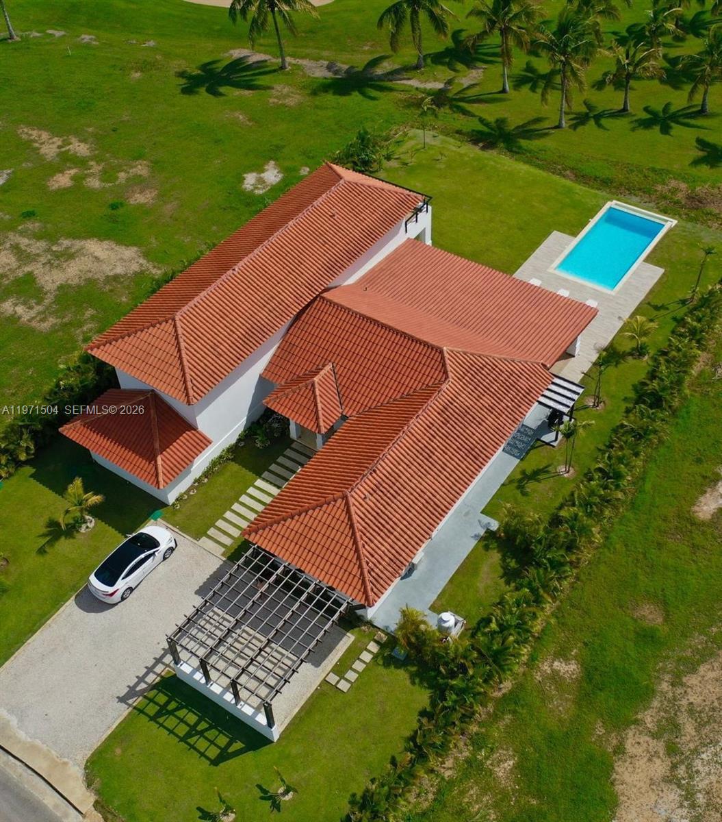 An aerial view shows a house with a red tile roof, pool, and pergola — Samanes, La Estancia Golf & Country Club, DR, DR
