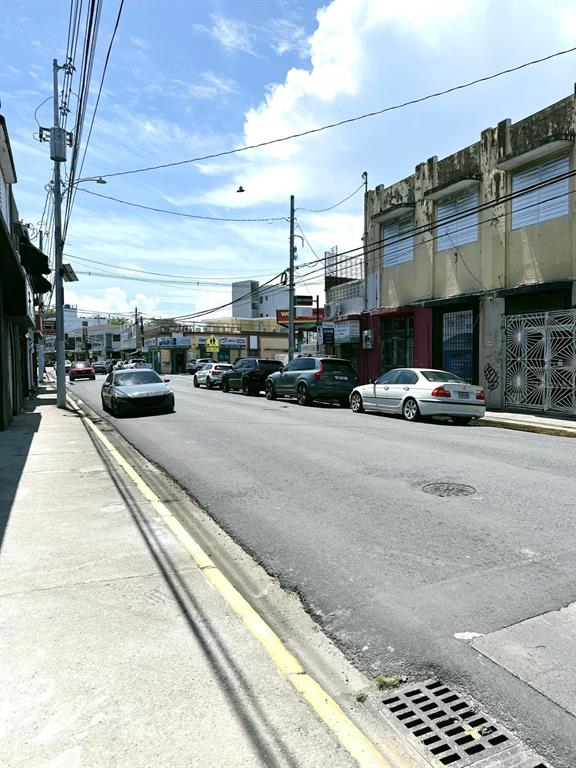 A street view shows a row of commercial buildings with parked cars along the road — 2024 LOIZA STREET, SAN JUAN, PR