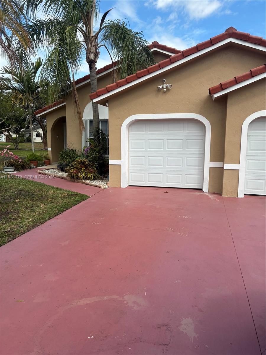 A tan house with a red-painted driveway and a white garage door — 18175 NW 61st Ave # 0, Miami FL 33015, MIAMI, FL