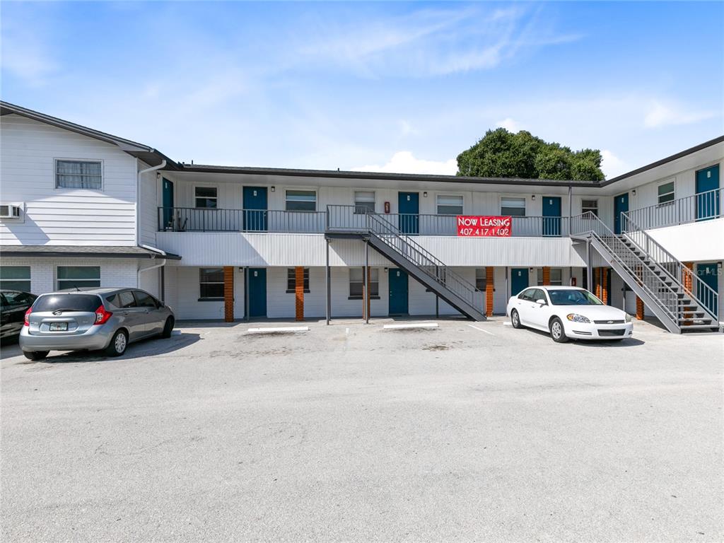 A two-story apartment building with exterior walkways, metal staircases, and a paved parking lot — 955 6TH STREET SE UNIT 5, WINTER HAVEN, FL