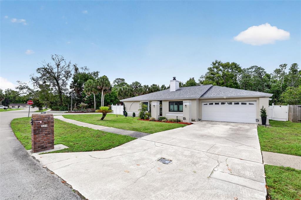 A single-story house with a beige exterior, a two-car garage, and a brick mailbox — 575 TIBERON COVE ROAD, LONGWOOD, FL