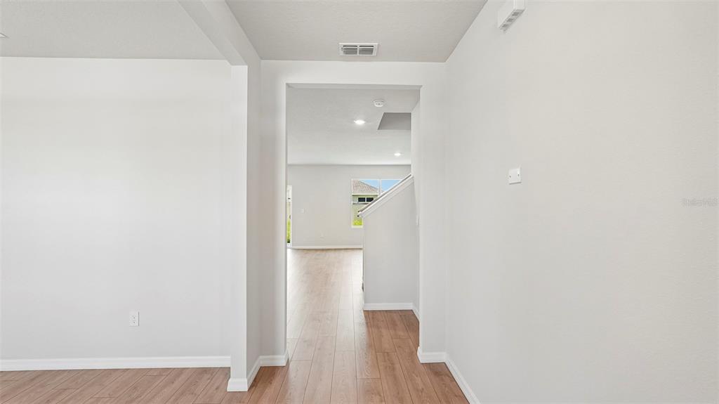 A view through a doorway shows a living area with light wood-look flooring — 5423 SILVER MOONLIGHT DRIVE, PALMETTO, FL