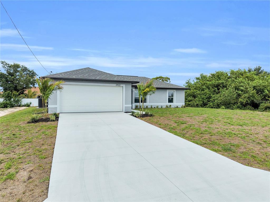 A single-story house with a white garage door and a concrete driveway — 310 NE 9TH TERRACE, CAPE CORAL, FL